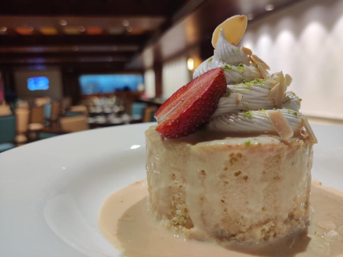 a piece of cake with a strawberry on top on a plate at The Orchid Shimla in Shimla