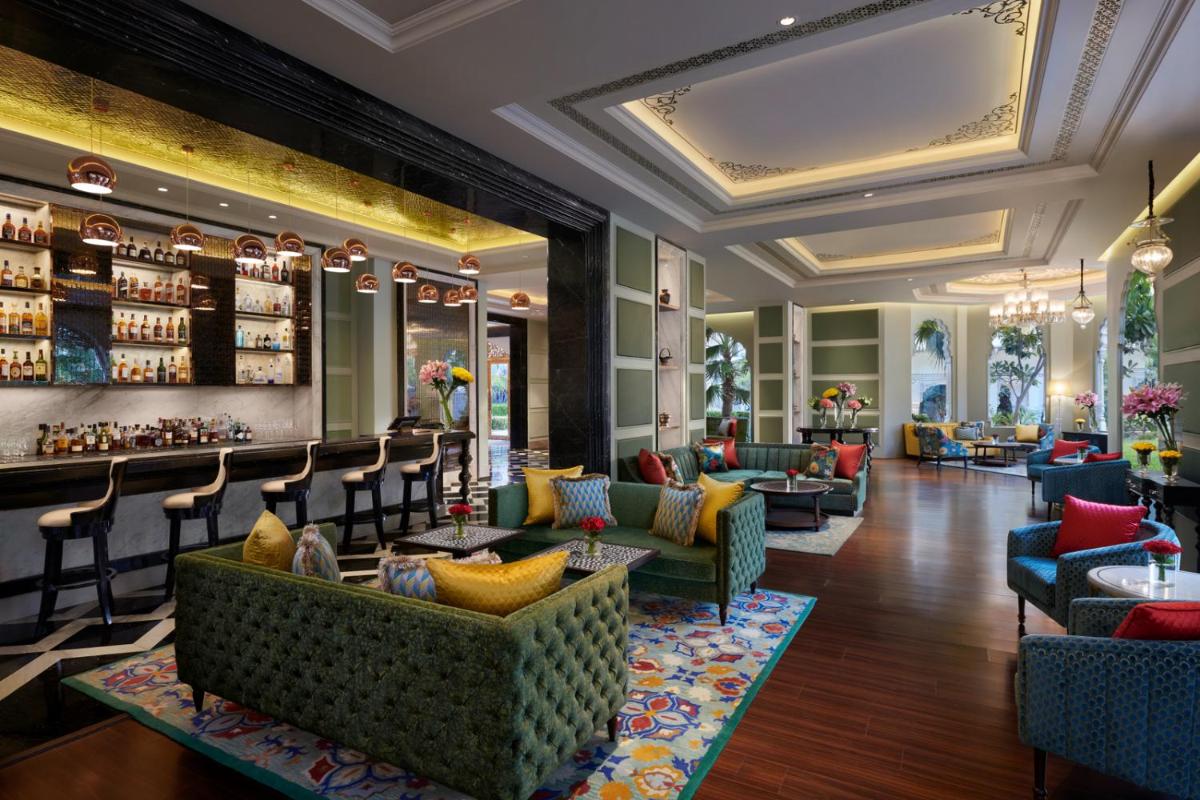 a lobby of a hotel with couches and a bar at The Leela Palace Jaipur in Jaipur