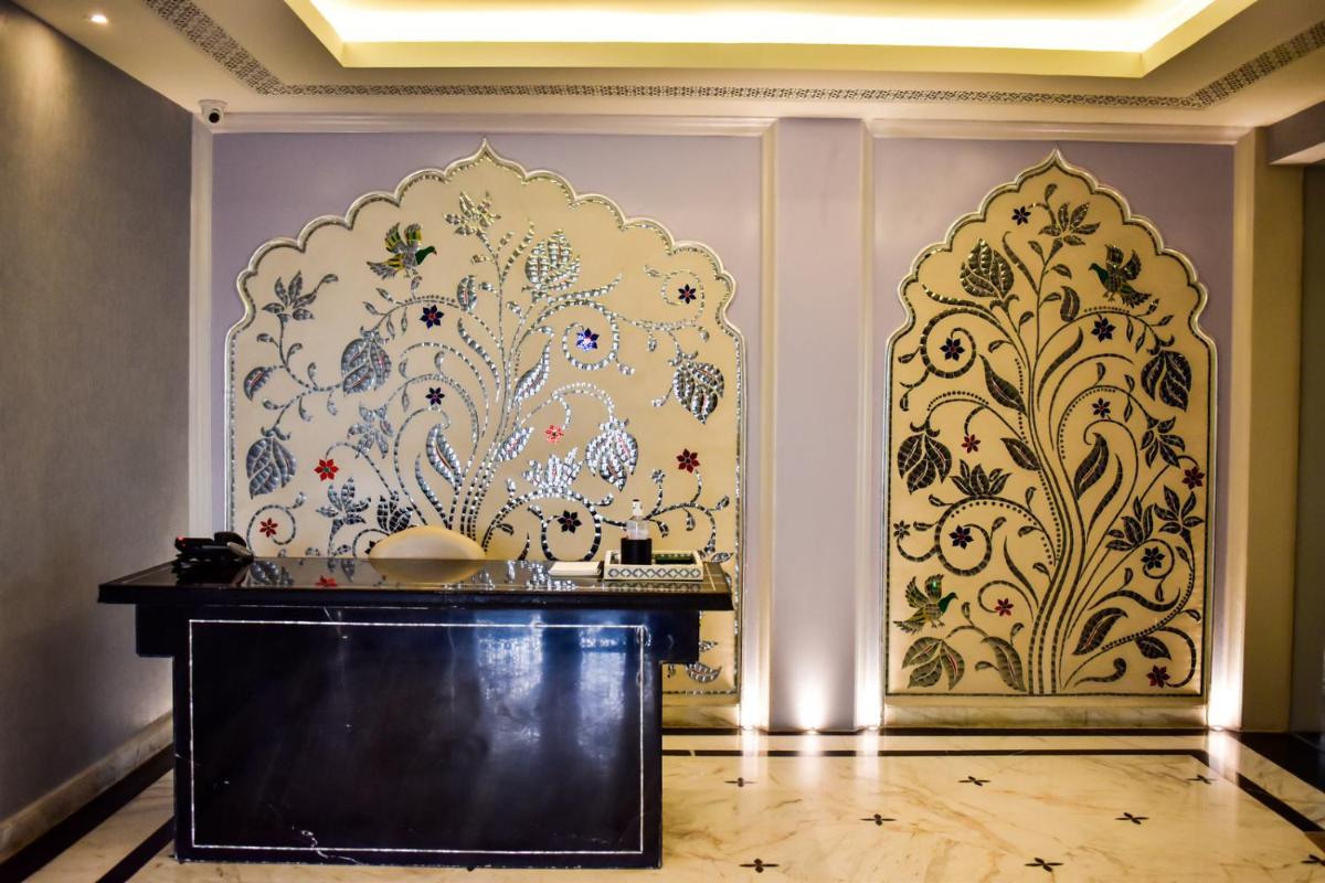 a room with a wall with a floral wallpaper at The Leela Palace Jaipur in Jaipur