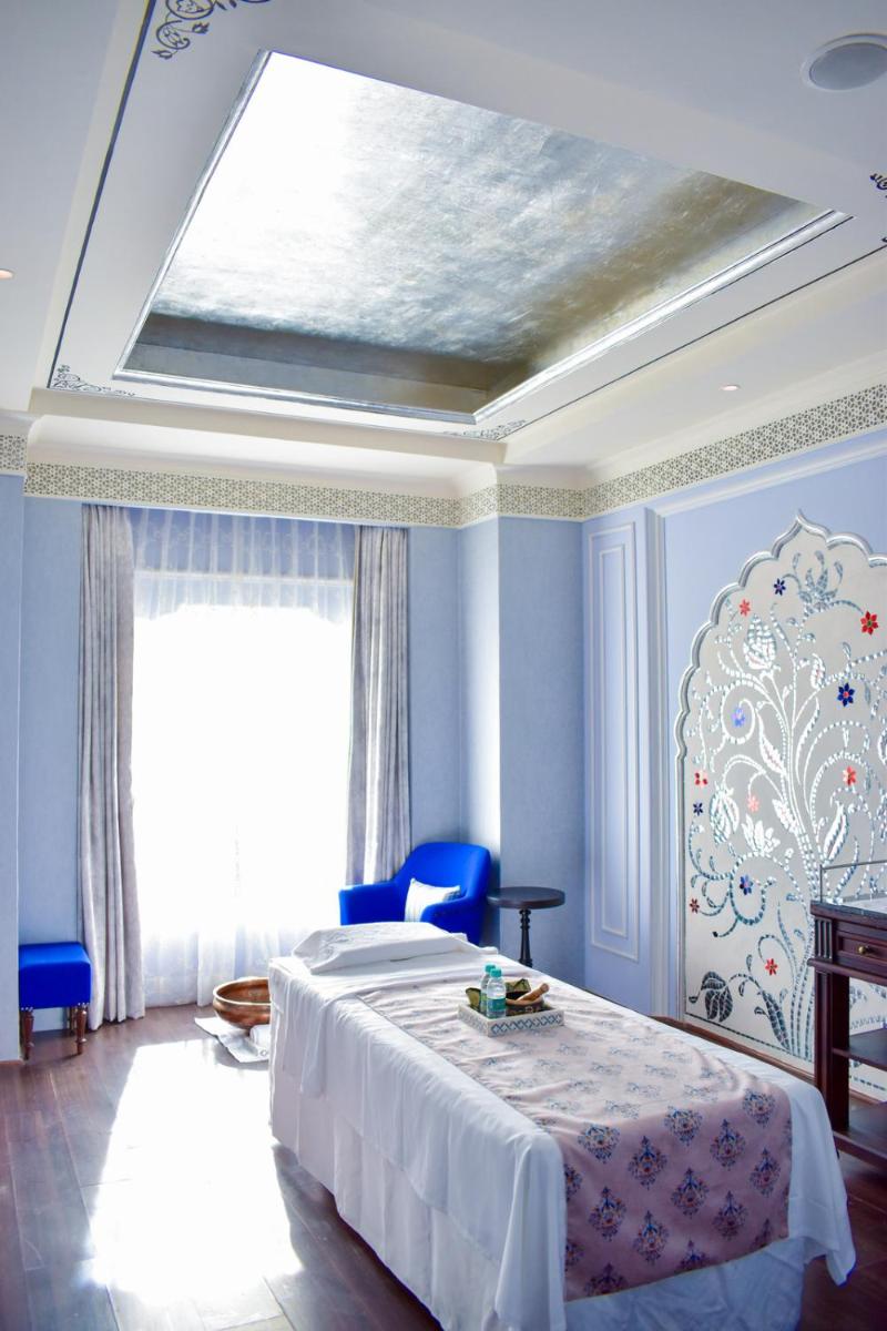 a bedroom with a bed and a ceiling with a window at The Leela Palace Jaipur in Jaipur