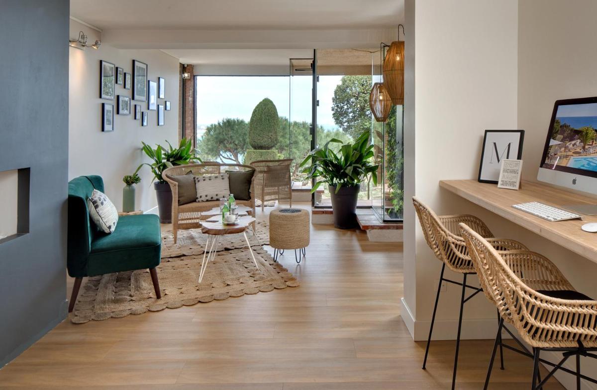 - un salon décloisonné avec un bureau et des chaises dans l'établissement Hôtel & Spa Les Mouettes, à Argelès-sur-Mer