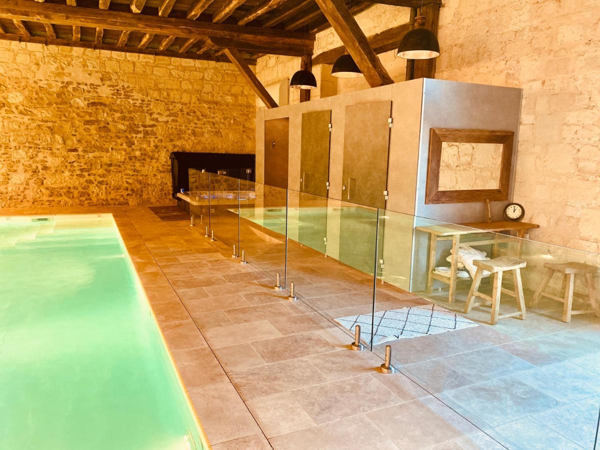 - une piscine dans une pièce avec une table et des chaises dans l'établissement Le Domaine de Mestré, The Originals Relais, à Fontevraud-l'Abbaye