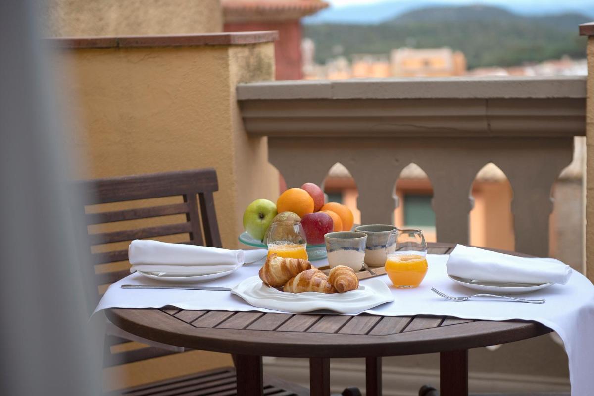 una mesa con un plato de fruta y vasos de zumo de naranja en Hotel Rosa & Spa Begur, en Begur