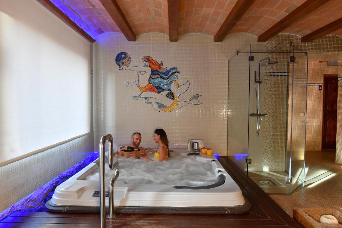 un hombre y una mujer en una bañera en Hotel Rosa & Spa Begur, en Begur