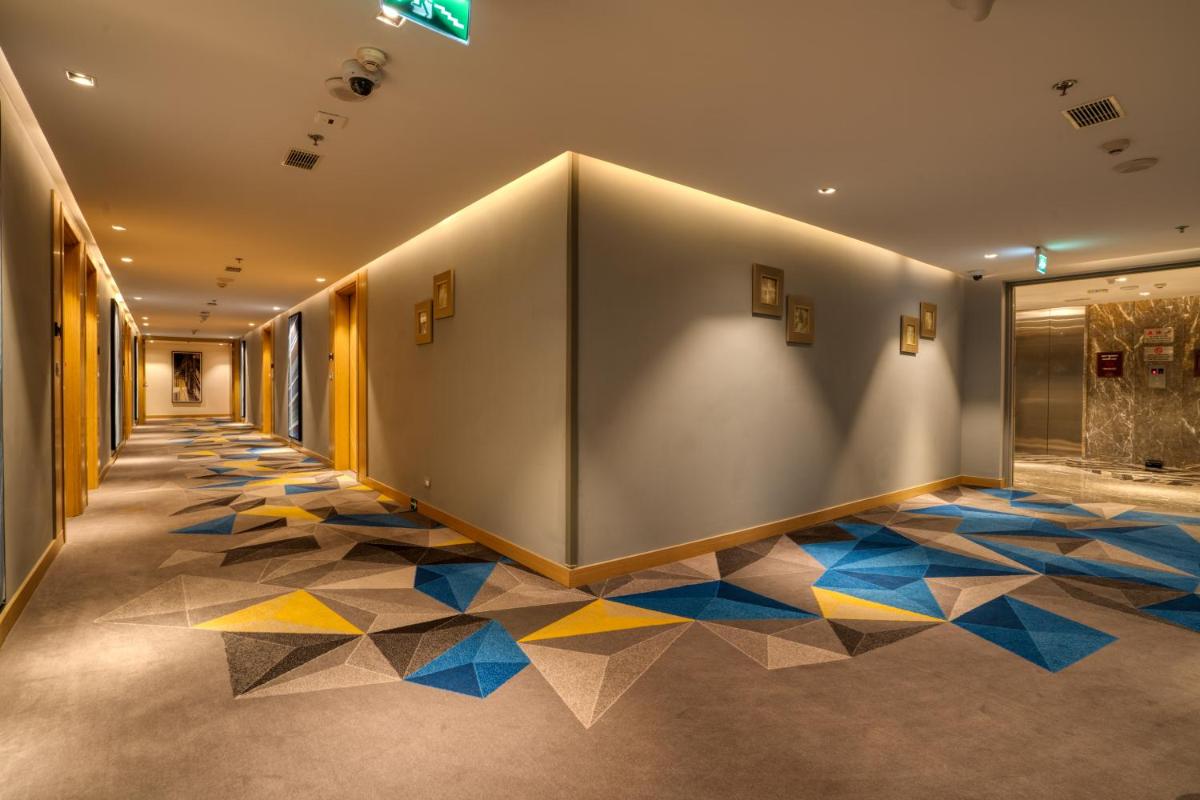 a hallway with a large wall with a colorful floor at Welcomhotel by ITC Hotels, RaceCourse, Coimbatore in Coimbatore