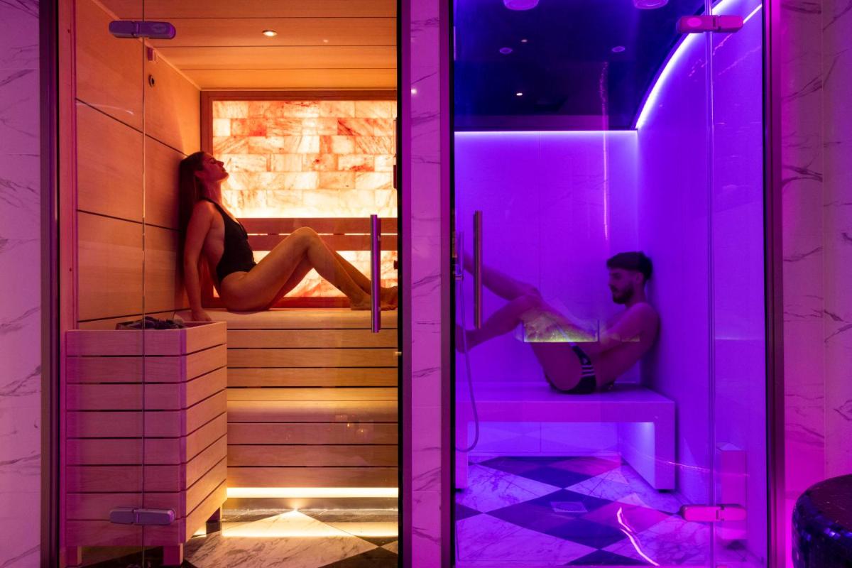 un homme et une femme assis dans un sauna avec des lumières violettes dans l'établissement Hotel & Spa Saint-Jacques, à Paris 53 autres photos