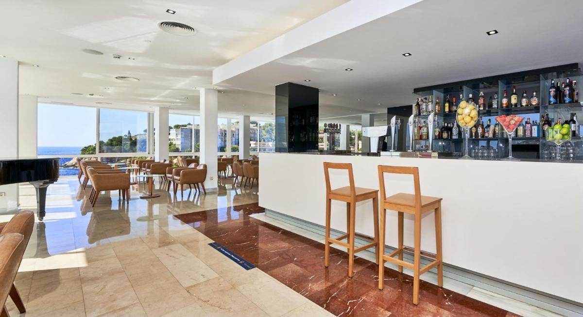 Un bar en un restaurante con vista al mar. en Globales Cala Viñas Adults Only 16+, en Cala Vinyes