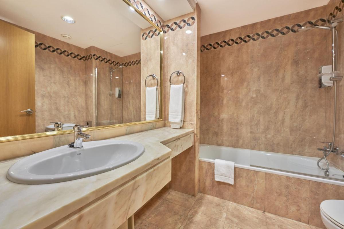 Un baño con lavabo, bañera e inodoro. en Globales Cala Viñas Adults Only 16+, en Cala Vinyes