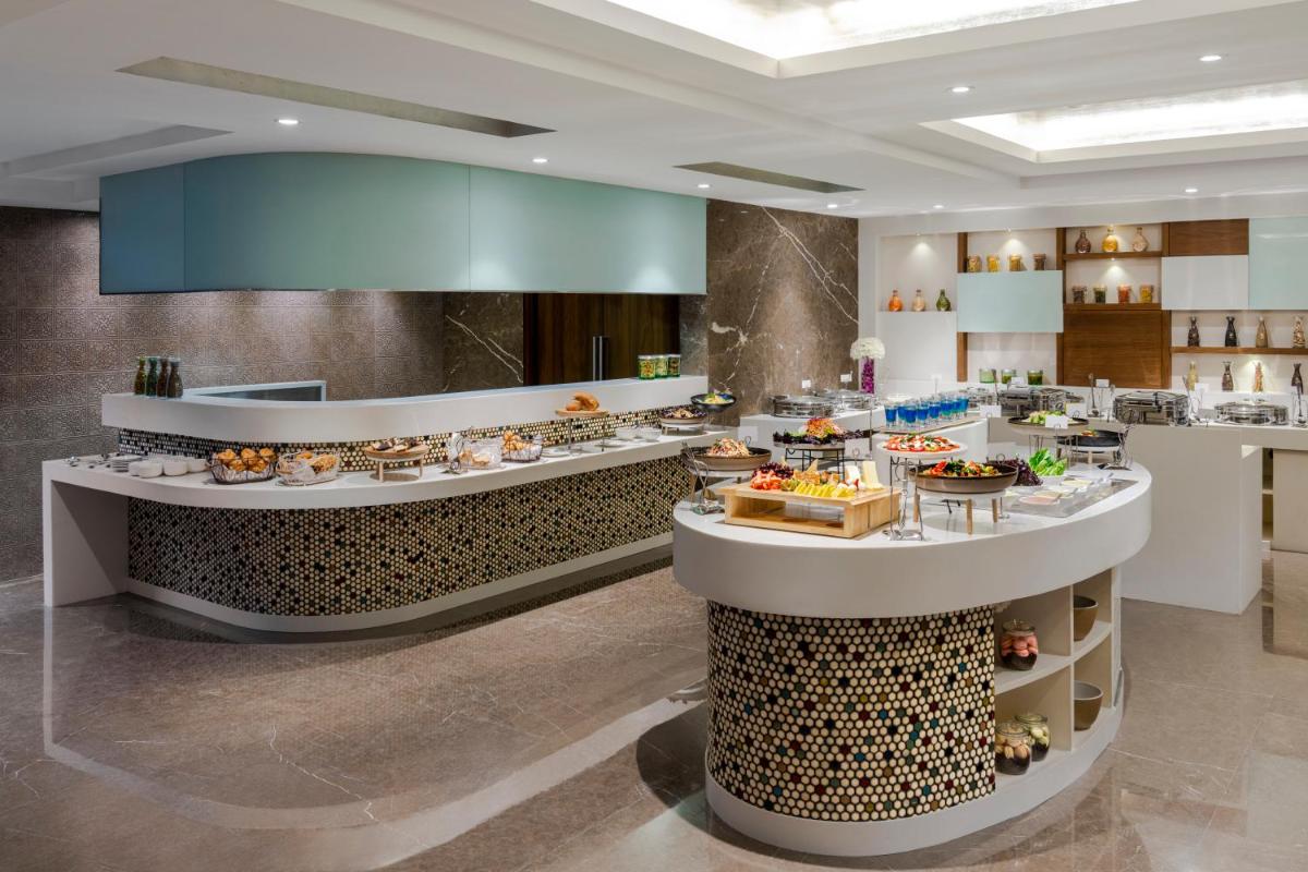 a restaurant with a buffet line with food on display at Vivanta Thiruvananthapuram in Trivandrum