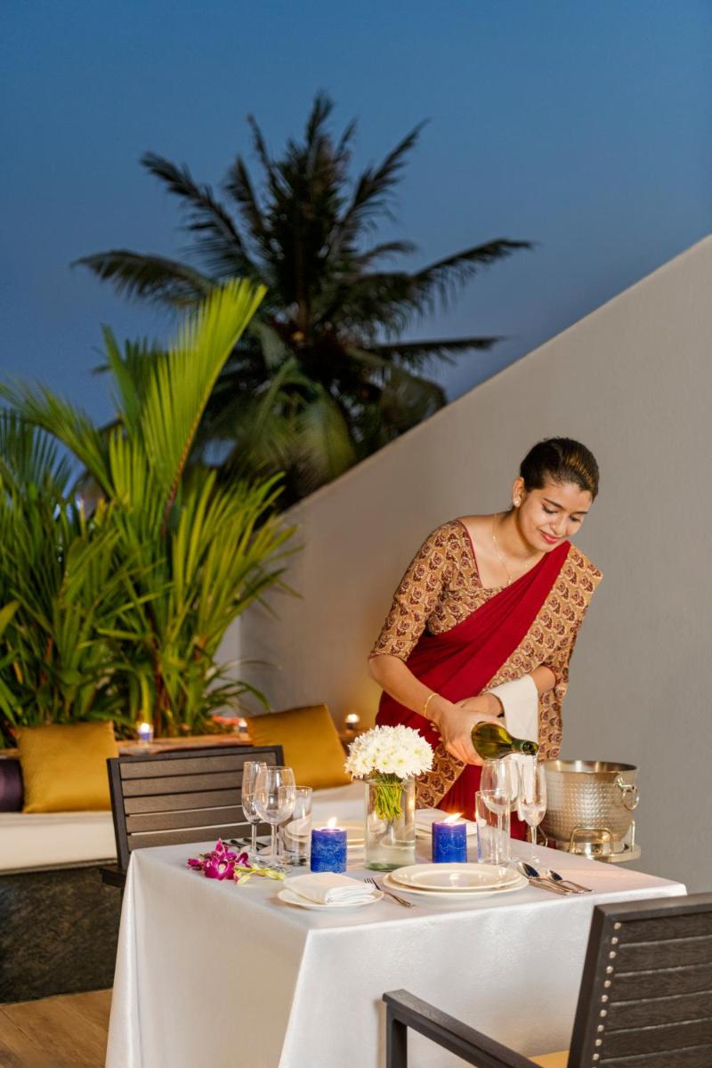 a woman is preparing food at a table at Vivanta Thiruvananthapuram in Trivandrum