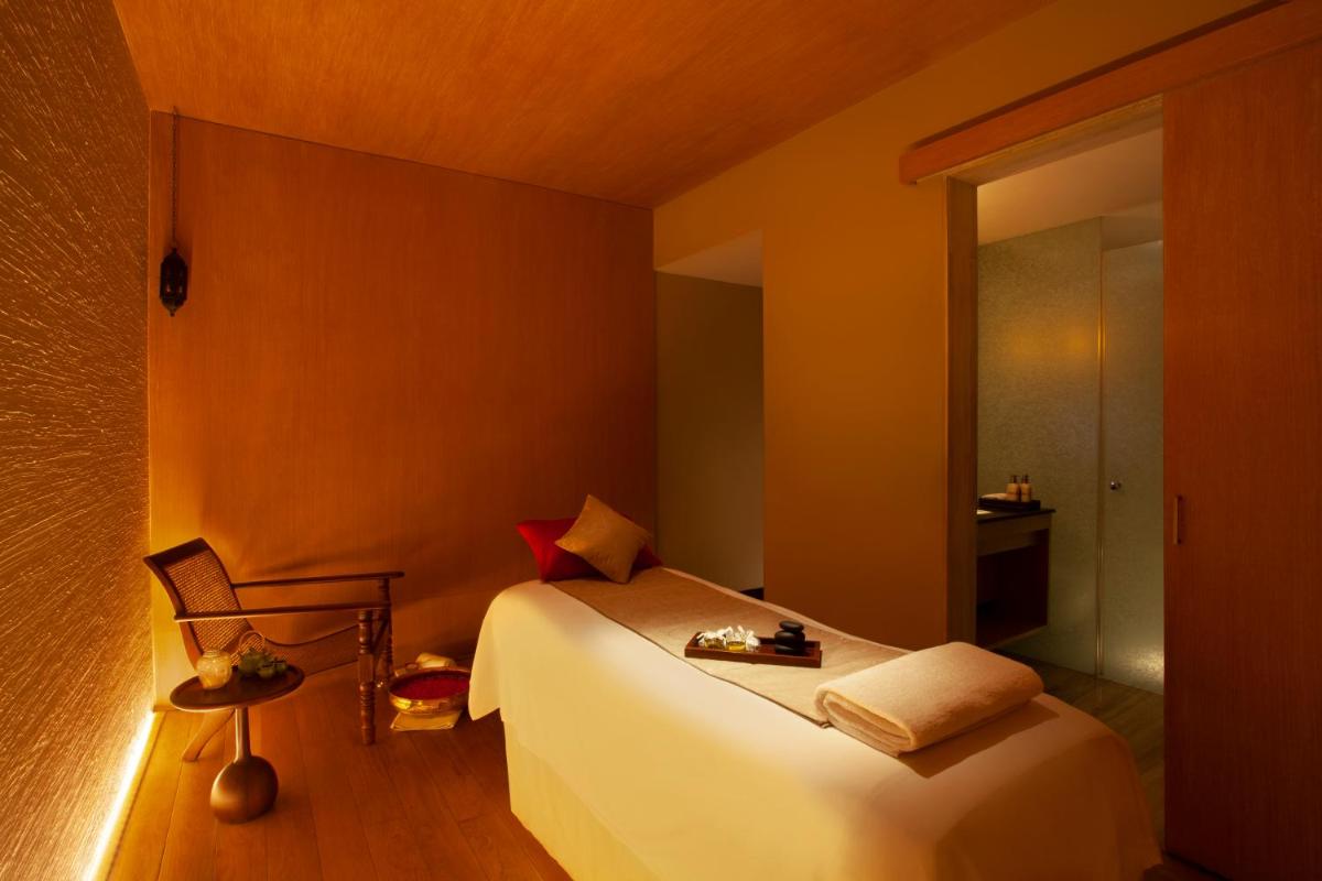 a bedroom with a white bed and a chair at Park Hyatt Chennai in Chennai