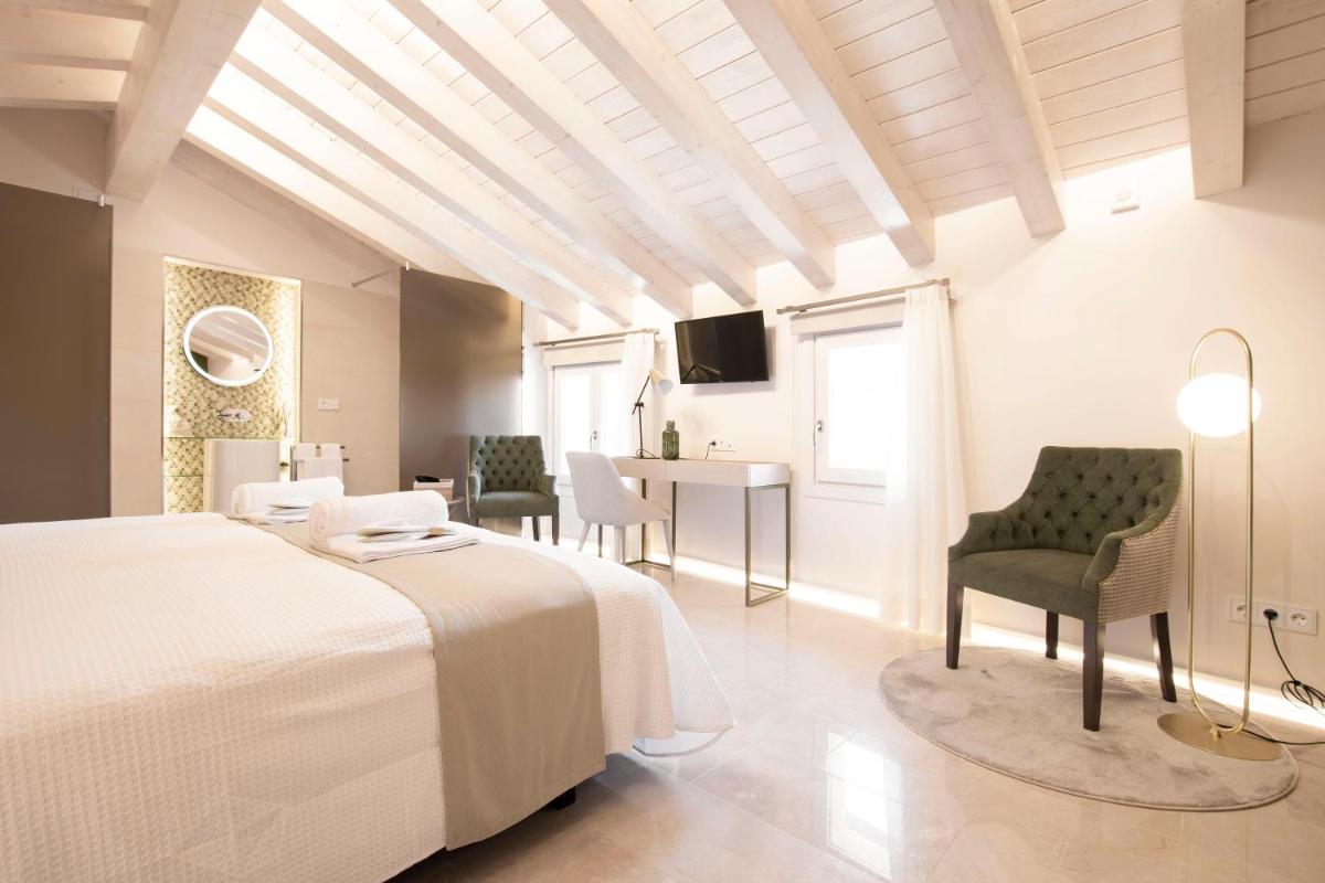 Un dormitorio con una cama y una mesa y sillas. en Hotel 1877 Sensaciones & SPA ADULTS ONLY, en Albarracín