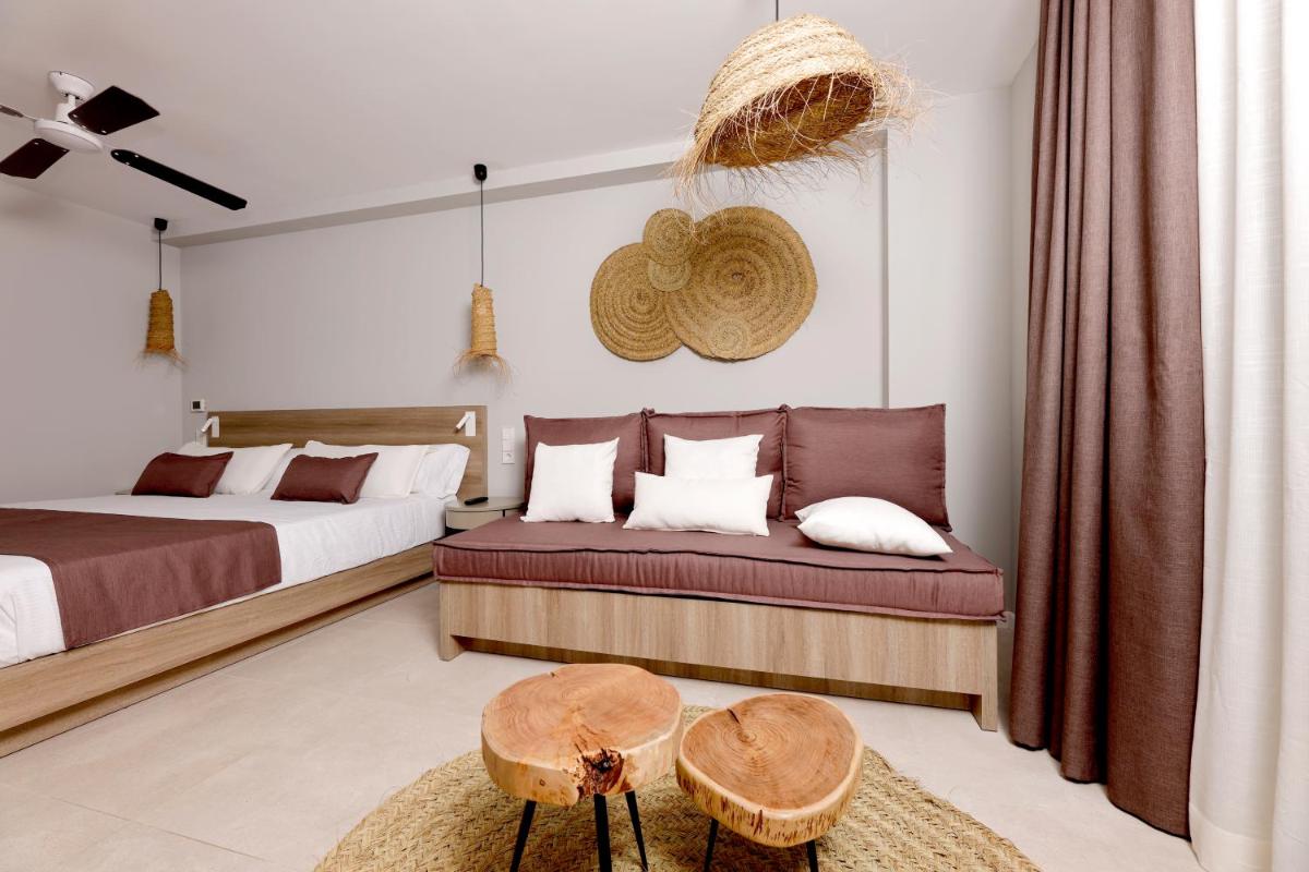 Un dormitorio con dos camas y un sofá y una mesa. en Eques Petit Resort, en Cala d´Or
