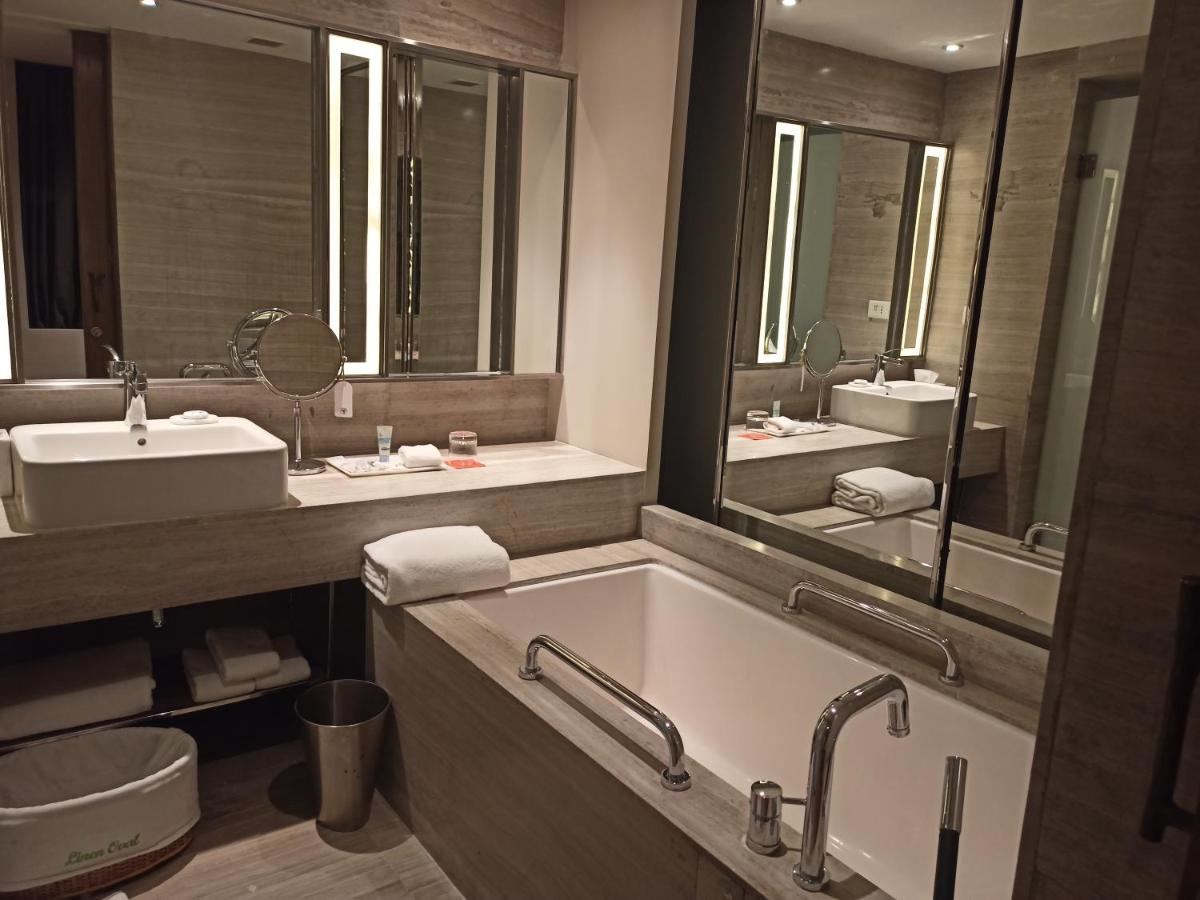 a bathroom with a tub and a sink and mirror at Welcomhotel by ITC Hotels, Richmond Road, Bengaluru in Bengaluru