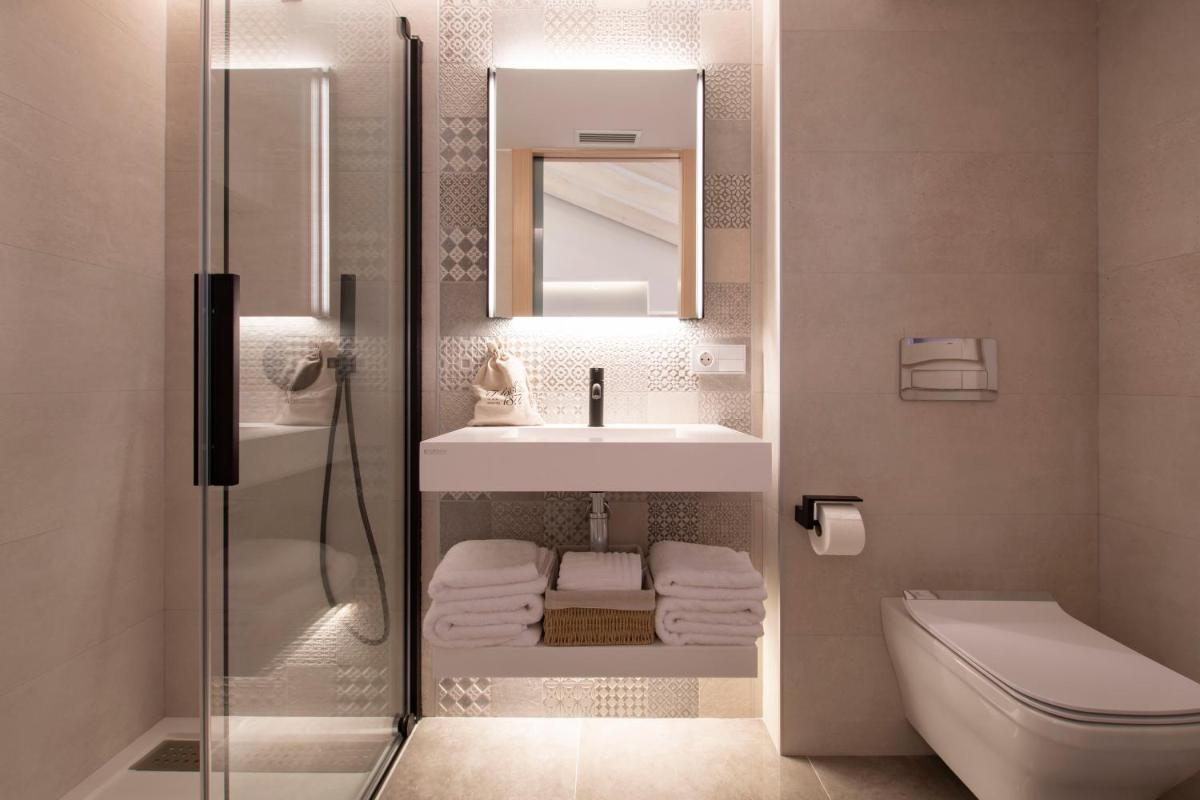 Un baño con lavabo, inodoro y espejo. en Hotel 1877 Sensaciones & SPA ADULTS ONLY, en Albarracín 37 fotos más