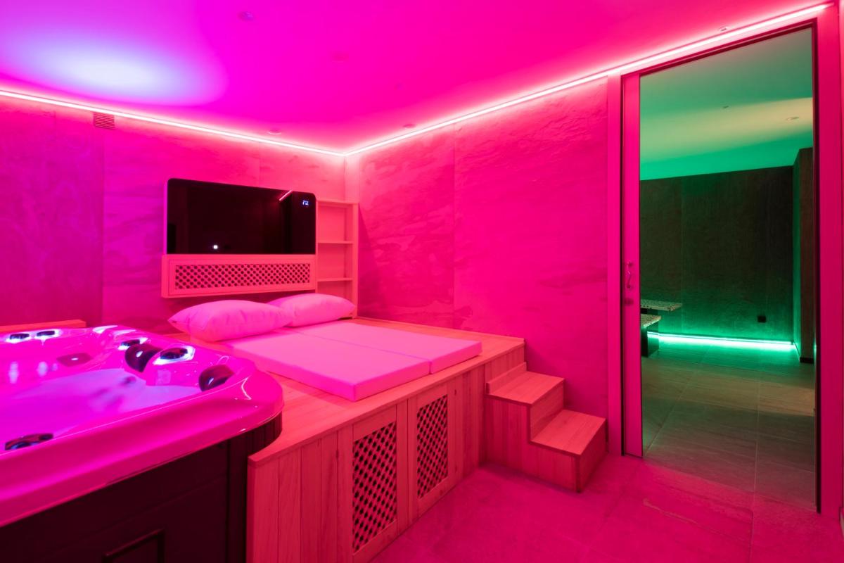 y baño de color rosa con lavabo y ducha. en Hotel 1877 Sensaciones & SPA ADULTS ONLY, en Albarracín