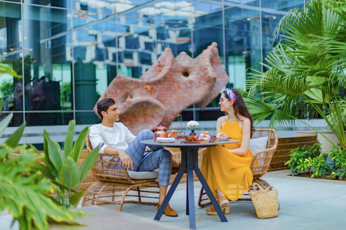 a man and a woman sitting at a table at Andaz Delhi, by Hyatt in New Delhi a man and a woman sitting at a table at Andaz Delhi, by Hyatt in New Delhi