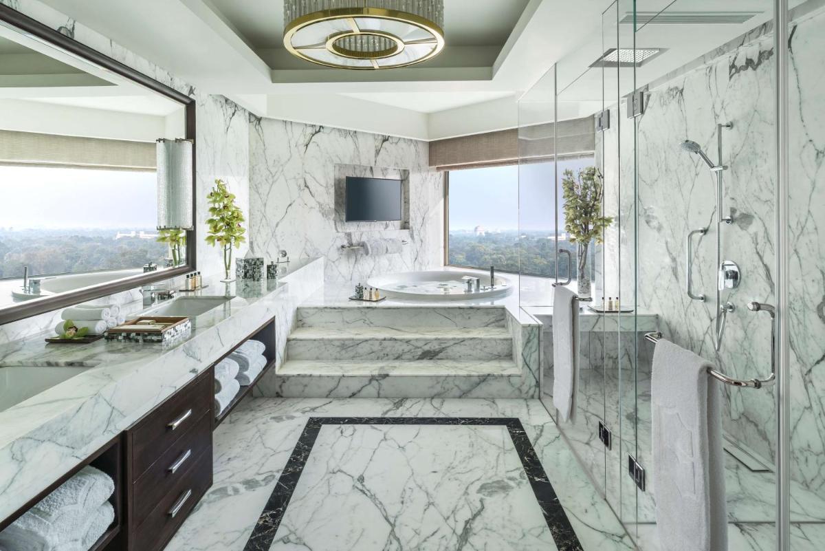 a bathroom with a tub and a sink at Shangri-La Eros New Delhi in New Delhi a bathroom with a tub and a sink at Shangri-La Eros New Delhi in New Delhi