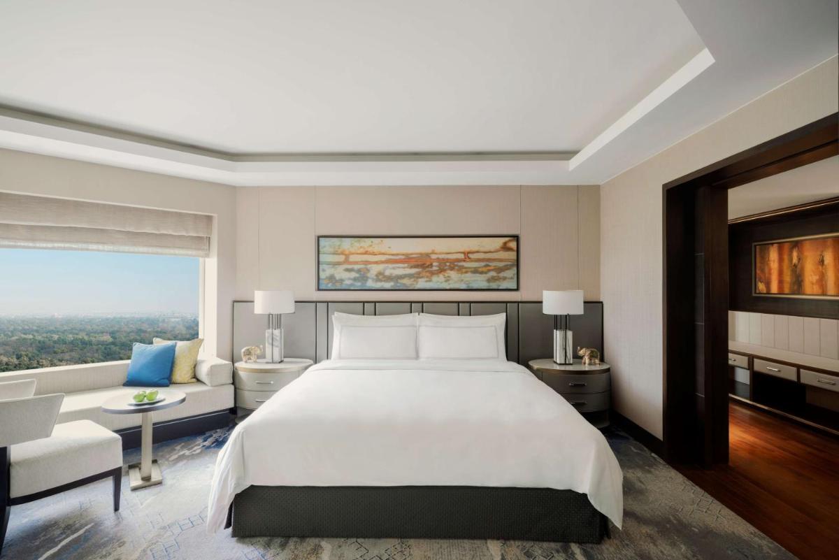 a bedroom with a large white bed and a couch at Shangri-La Eros New Delhi in New Delhi a bedroom with a large white bed and a couch at Shangri-La Eros New Delhi in New Delhi