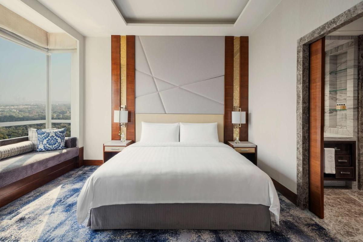 a bedroom with a white bed and a large window at Shangri-La Eros New Delhi in New Delhi a bedroom with a white bed and a large window at Shangri-La Eros New Delhi in New Delhi