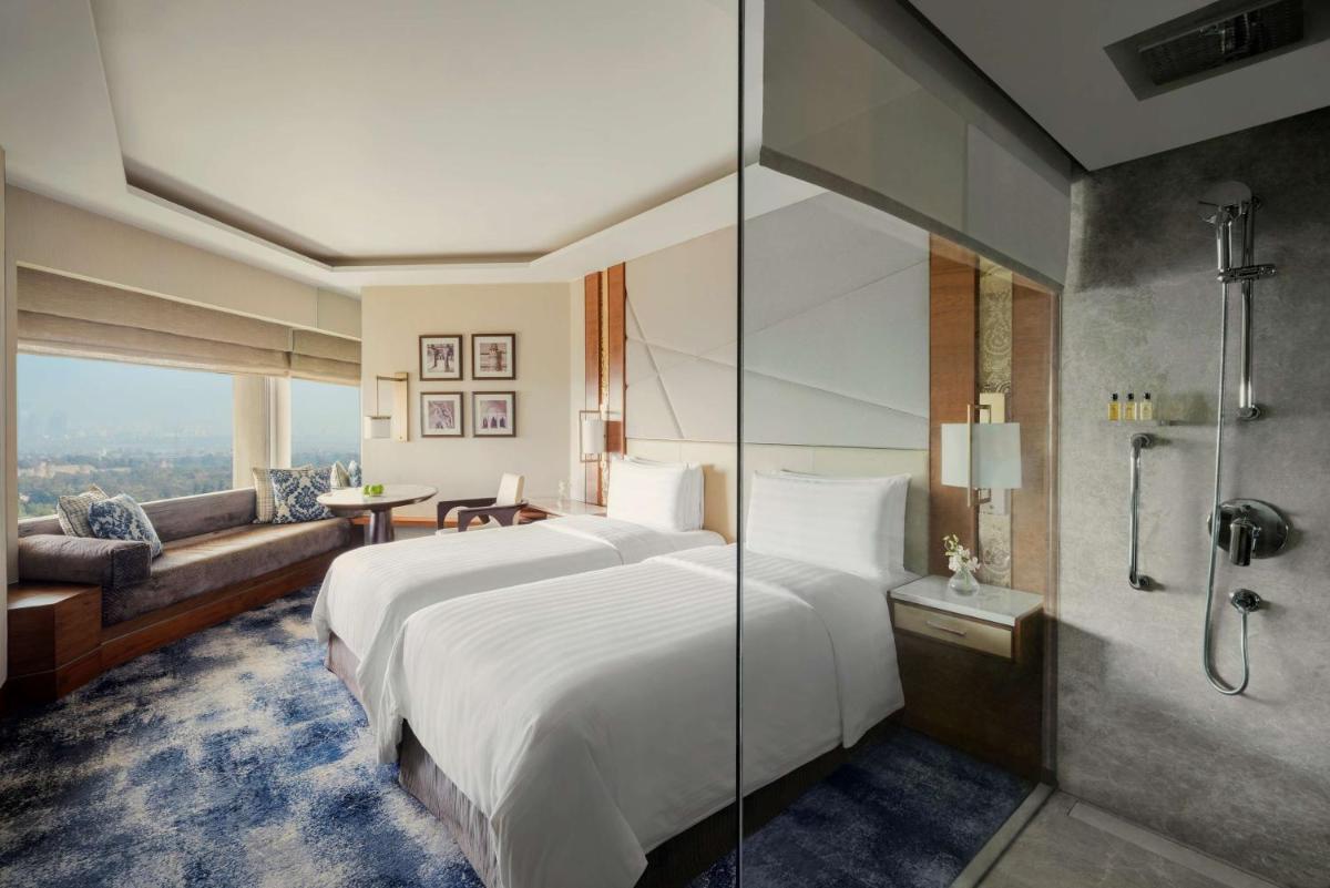 a bedroom with a large bed and a shower at Shangri-La Eros New Delhi in New Delhi a bedroom with a large bed and a shower at Shangri-La Eros New Delhi in New Delhi