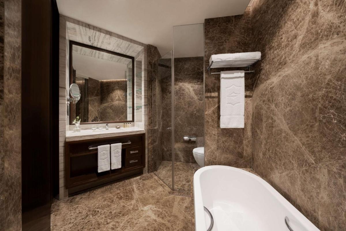 a bathroom with a tub and a sink at Shangri-La Eros New Delhi in New Delhi a bathroom with a tub and a sink at Shangri-La Eros New Delhi in New Delhi