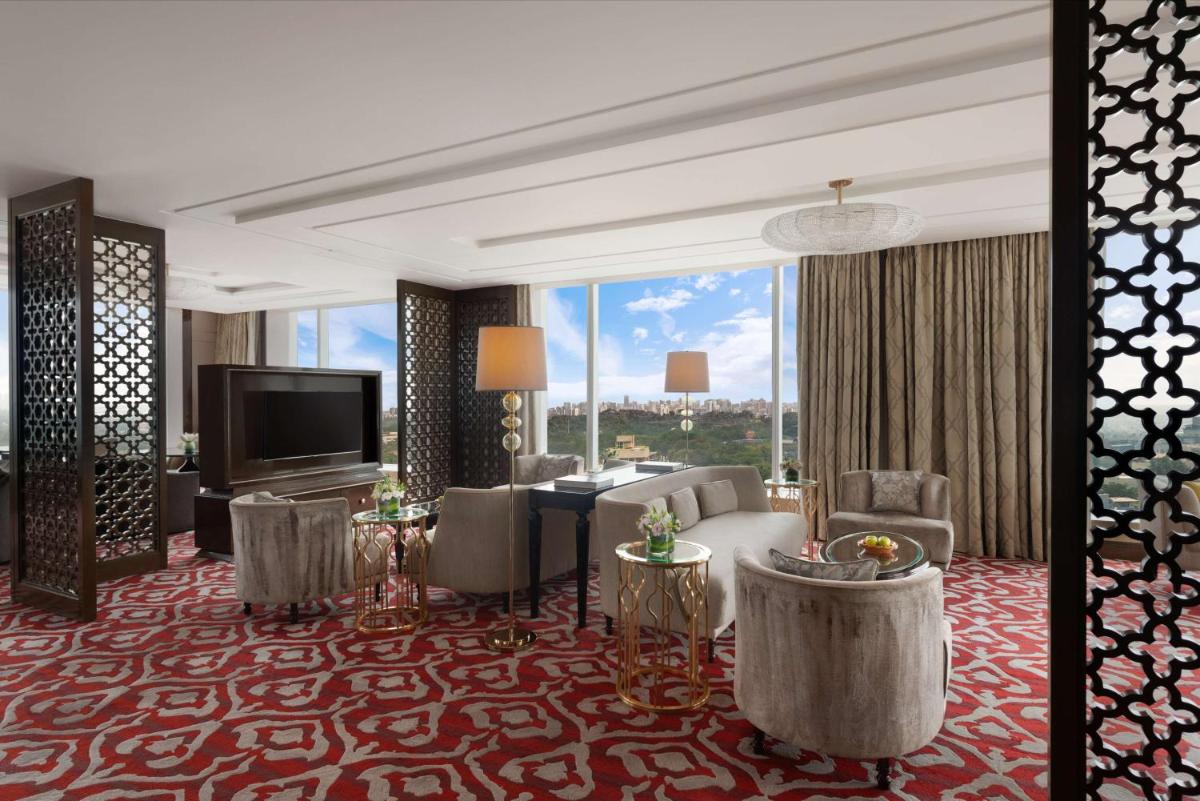 a living room with a couch and a television at Shangri-La Bengaluru in Bengaluru a living room with a couch and a television at Shangri-La Bengaluru in Bengaluru