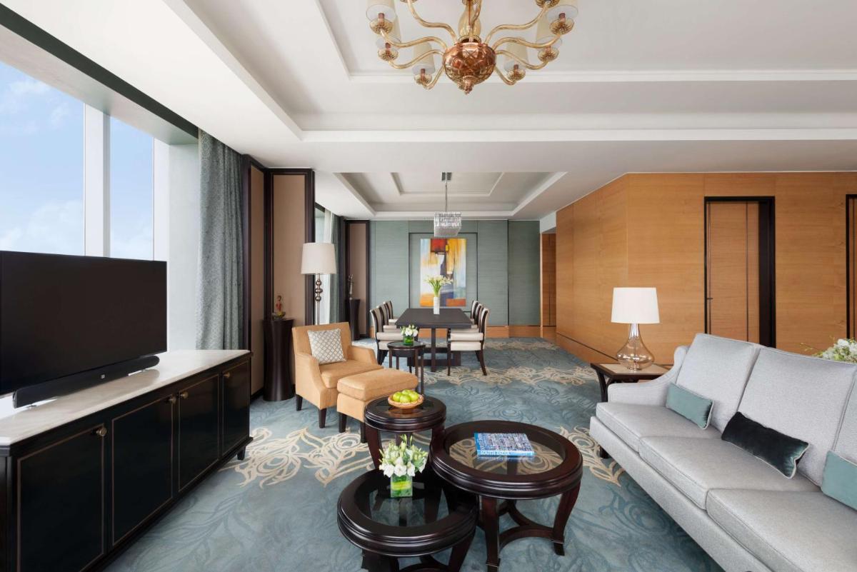 a living room with a couch and a tv at Shangri-La Bengaluru in Bengaluru a living room with a couch and a tv at Shangri-La Bengaluru in Bengaluru