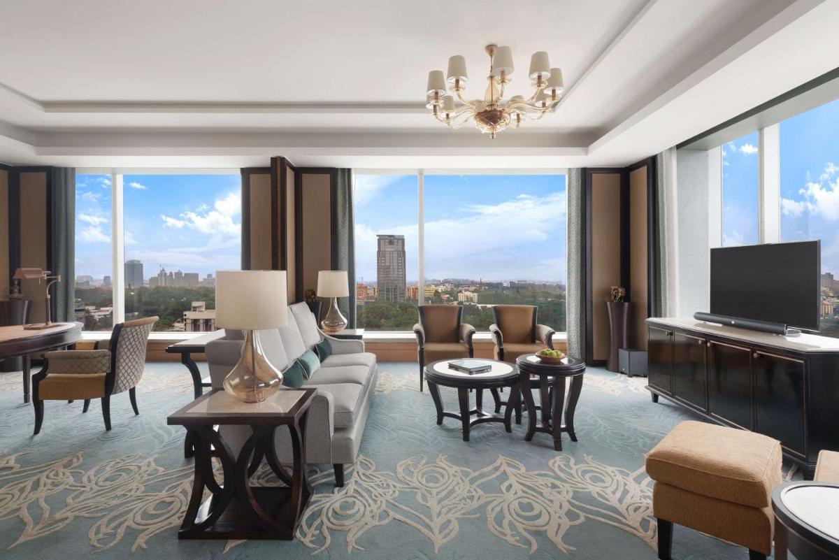 a living room with a couch and a tv at Shangri-La Bengaluru in Bengaluru a living room with a couch and a tv at Shangri-La Bengaluru in Bengaluru