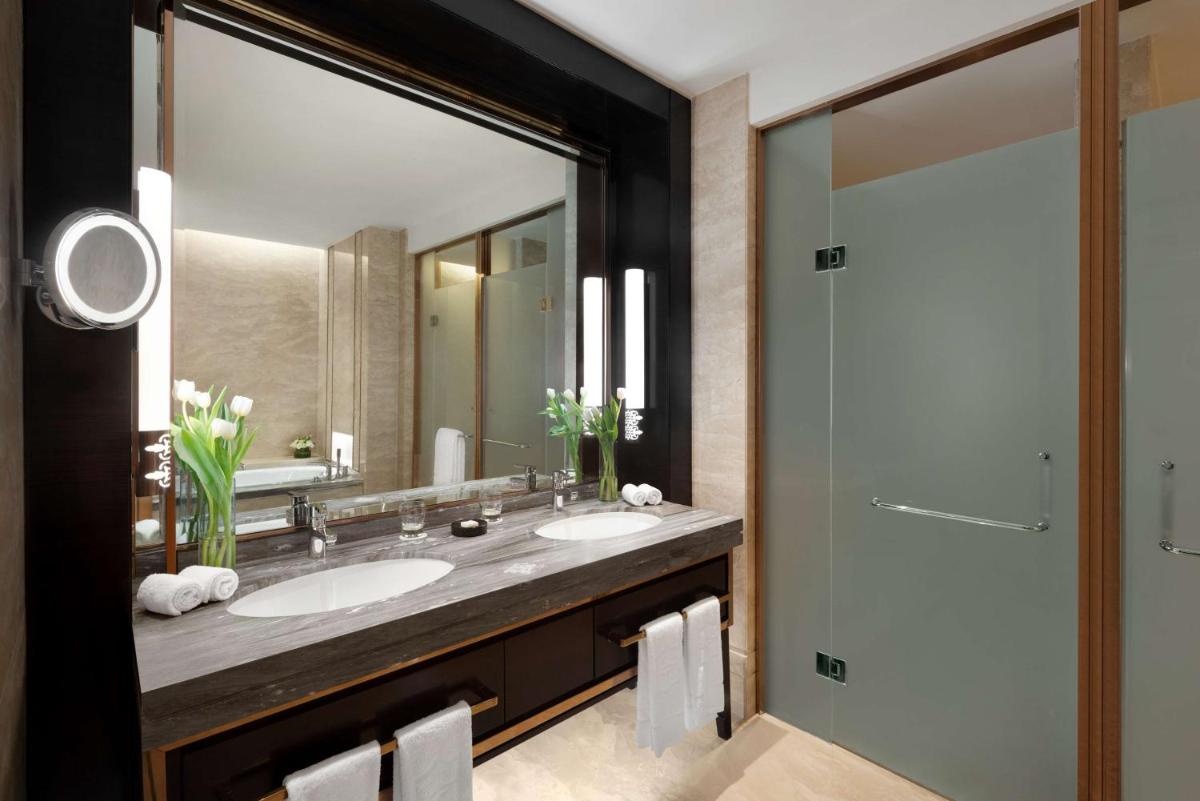 a bathroom with two sinks and a large mirror at Shangri-La Bengaluru in Bengaluru a bathroom with two sinks and a large mirror at Shangri-La Bengaluru in Bengaluru