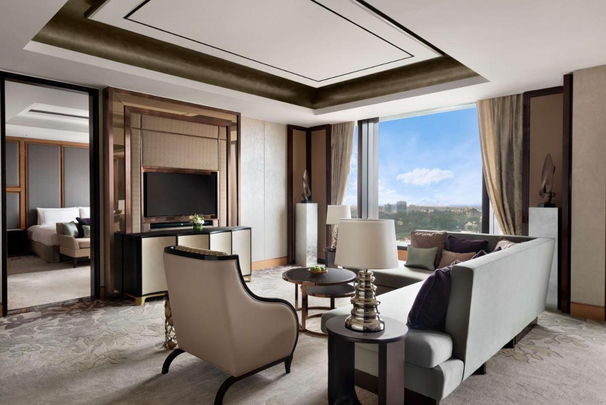 a living room with a couch and a television at Shangri-La Bengaluru in Bengaluru a living room with a couch and a television at Shangri-La Bengaluru in Bengaluru