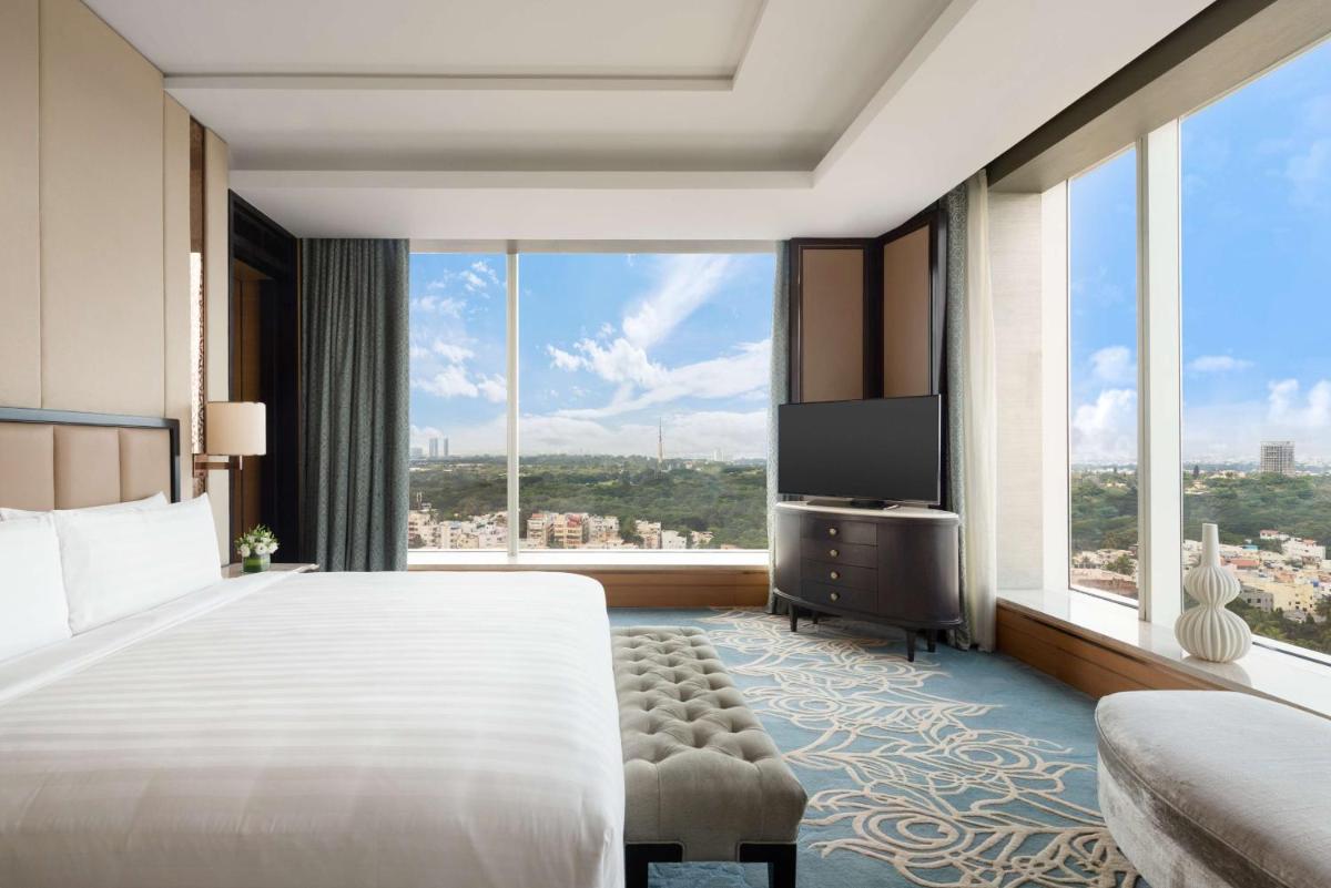 a bedroom with a large bed and a large window at Shangri-La Bengaluru in Bengaluru a bedroom with a large bed and a large window at Shangri-La Bengaluru in Bengaluru