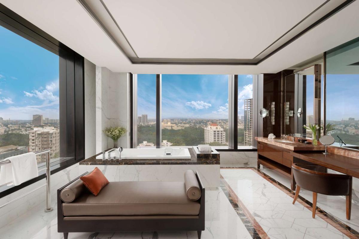 a bathroom with a couch and a tub and windows at Shangri-La Bengaluru in Bengaluru a bathroom with a couch and a tub and windows at Shangri-La Bengaluru in Bengaluru