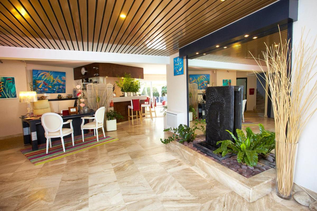 un salon avec une cuisine et une salle à manger dans l'établissement Carnac Lodge Hotel & Spa, à Plouharnel