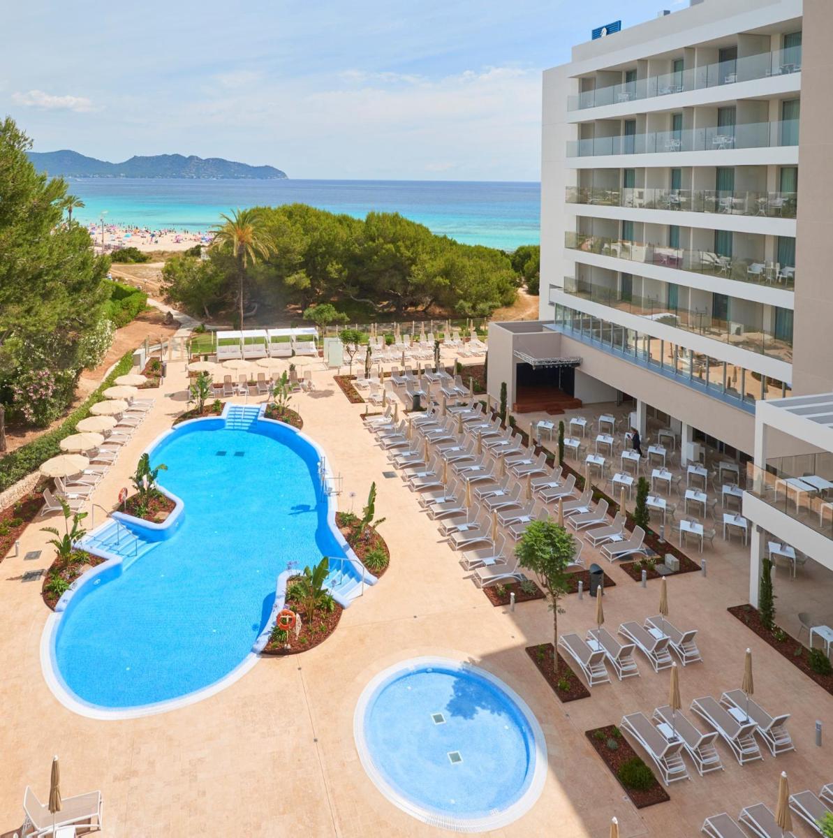 una vista aérea de un complejo con piscina y sillas en Hipotels Bahia Cala Millor - Adults Only, en Cala Millor