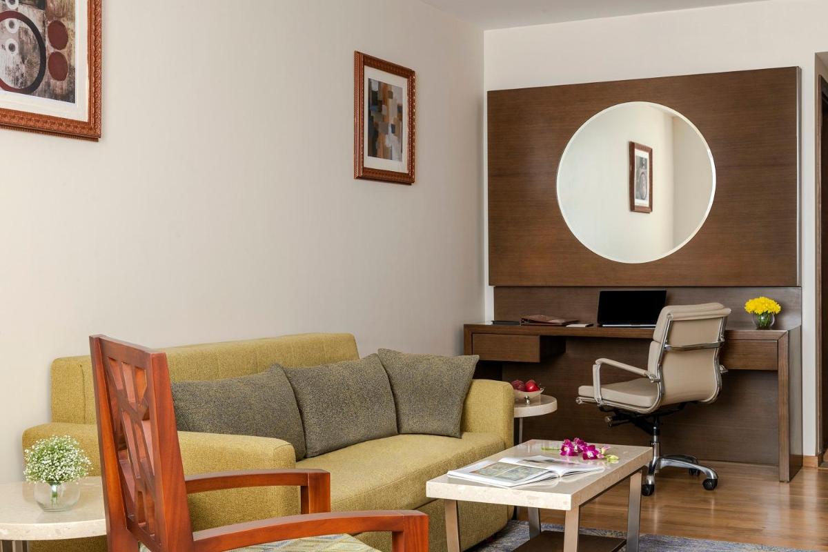 a living room with a couch and a table at Vivanta Thiruvananthapuram in Trivandrum