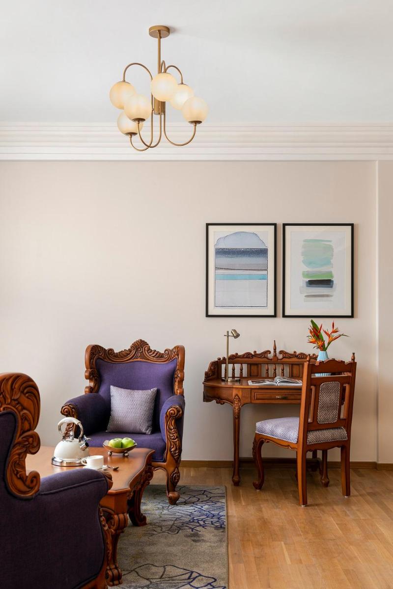 a living room with two chairs and a table at Vivanta Thiruvananthapuram in Trivandrum