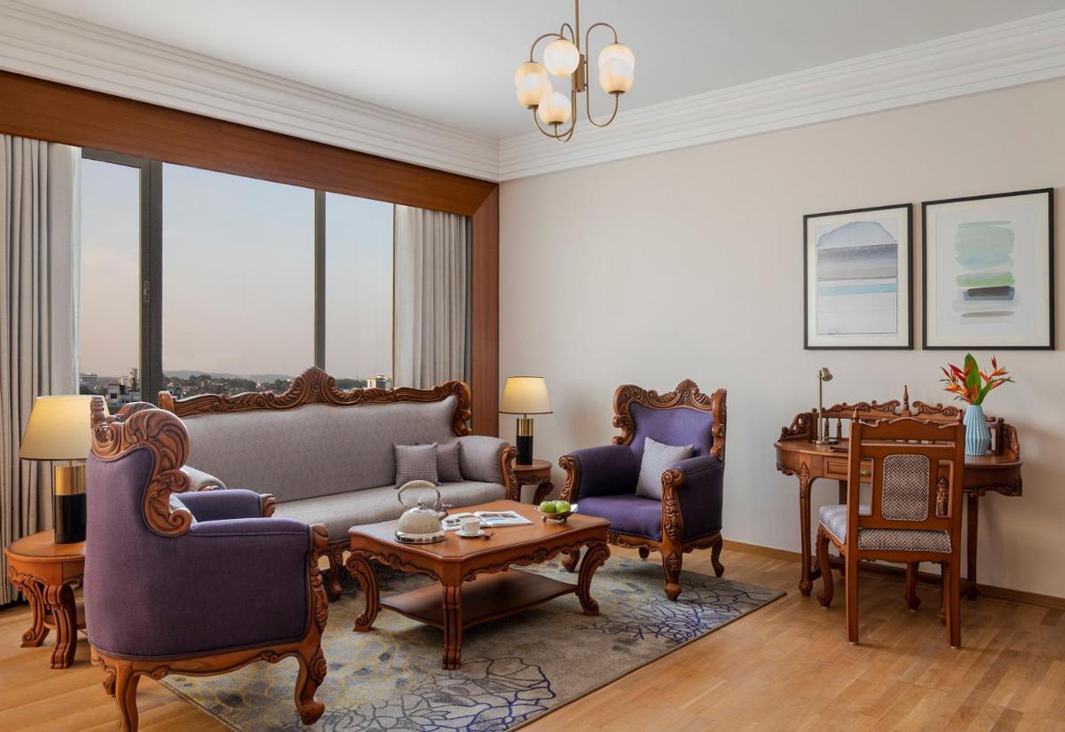 a living room with a couch and chairs and a table at Vivanta Thiruvananthapuram in Trivandrum