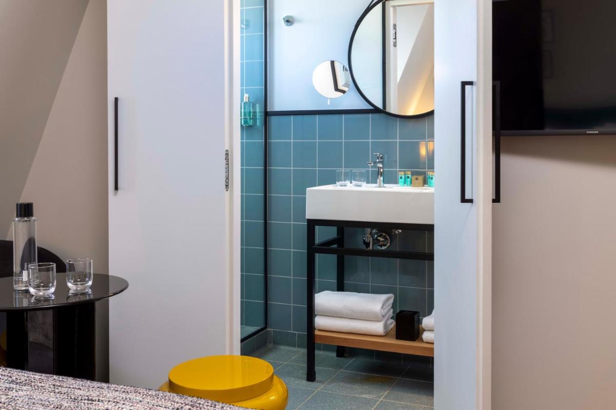 une salle de bain avec un lavabo et un miroir dans l'établissement Hotel Le 37 Bis, à Neuilly-sur-Seine