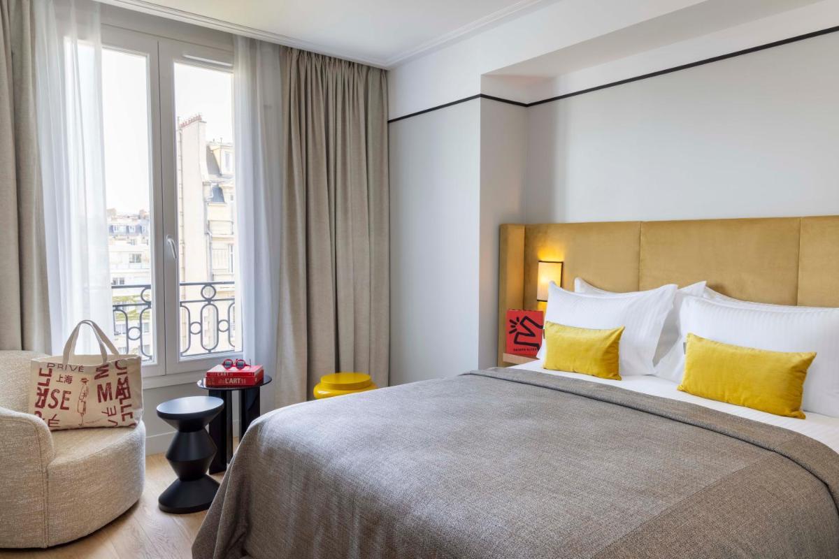 une chambre avec un lit, une chaise et une fenêtre dans l'établissement Hotel Le 37 Bis, à Neuilly-sur-Seine
