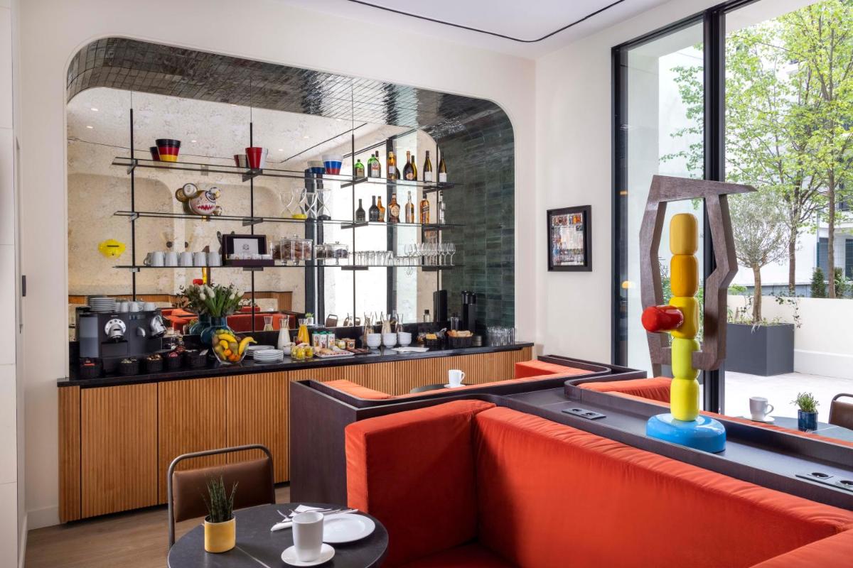 un restaurant avec un canapé rouge et un bar dans l'établissement Hotel Le 37 Bis, à Neuilly-sur-Seine