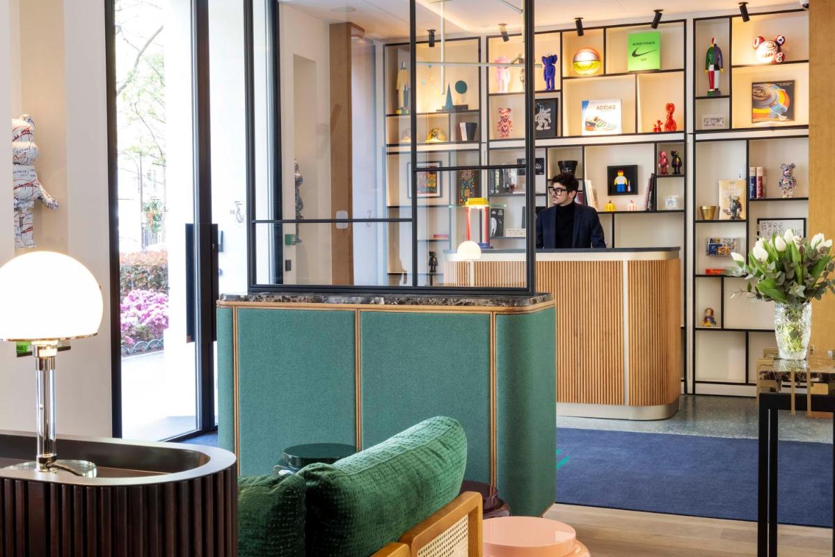 une femme debout au comptoir d'un magasin dans l'établissement Hotel Le 37 Bis, à Neuilly-sur-Seine