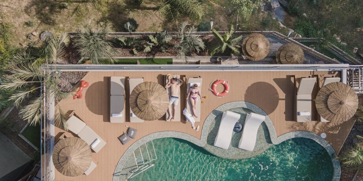 una vista aérea de un complejo con dos mujeres de pie en la playa en Casa Coco Boutique Hotel & Spa 4*S - Adults Only, en Lloret de Mar