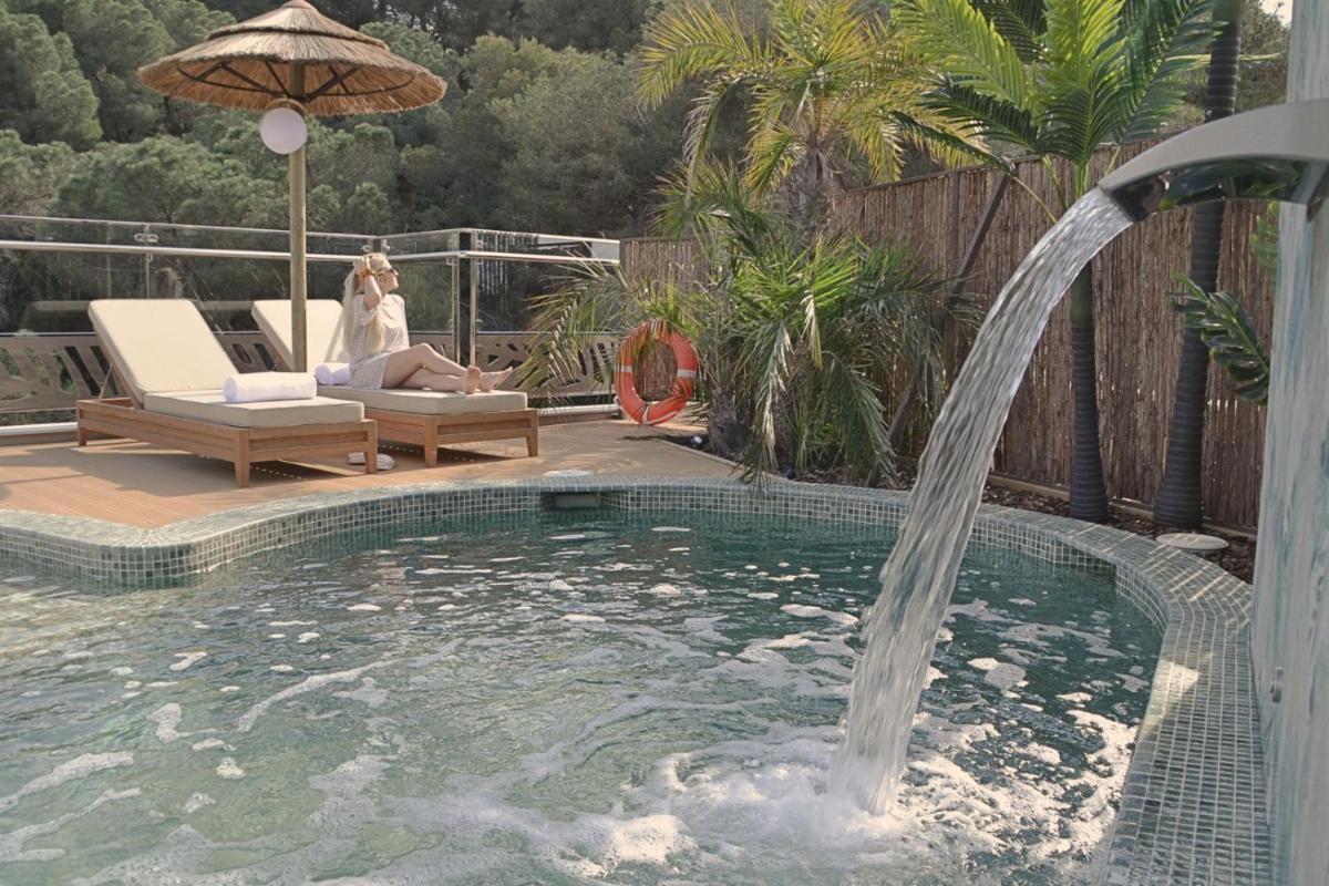 una mujer sentada en una silla junto a una piscina en Casa Coco Boutique Hotel & Spa 4*S - Adults Only, en Lloret de Mar
