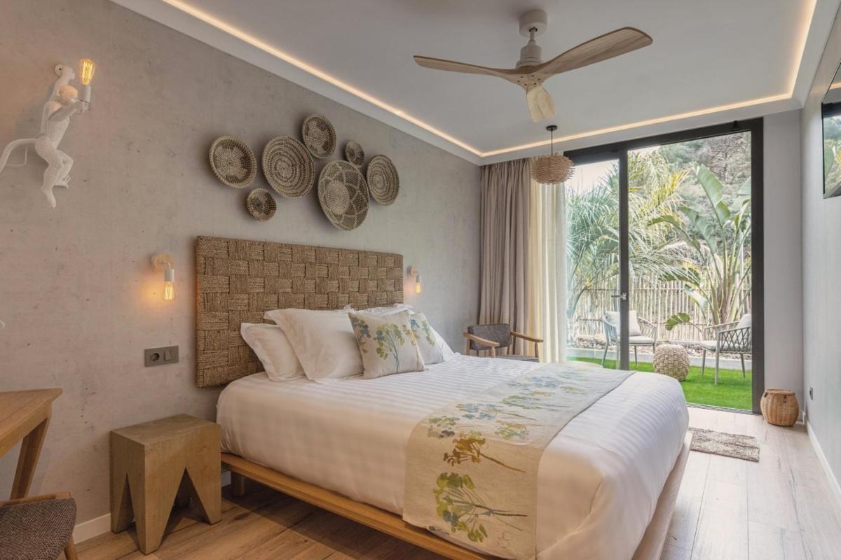 Un dormitorio con una cama grande y una ventana grande. en Casa Coco Boutique Hotel & Spa 4*S - Adults Only, en Lloret de Mar