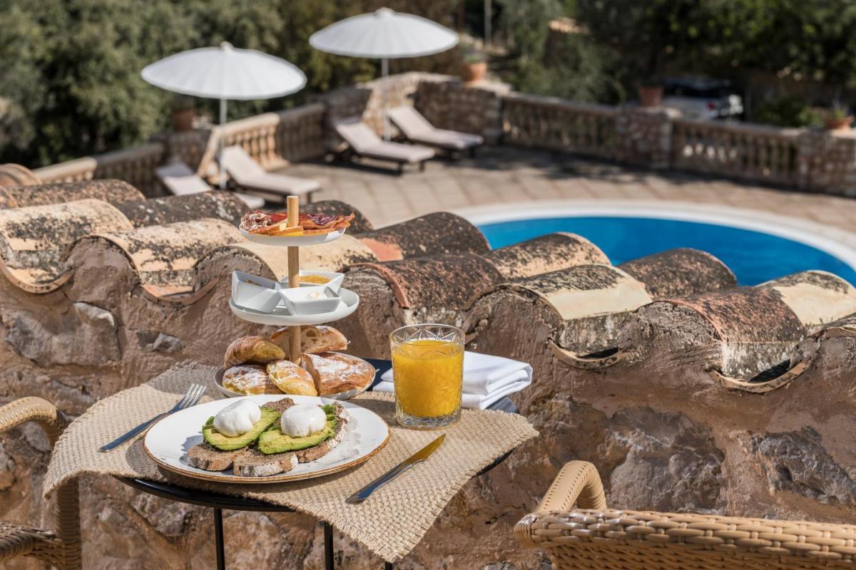 una mesa con dos platos de comida y un vaso de jugo de naranja en Ca'n Beneït, en Binibona