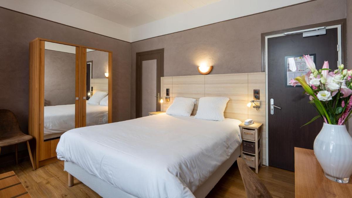Un ou plusieurs lits dans un hébergement de l'établissement Logis Central Hôtel - Restaurant & Spa
