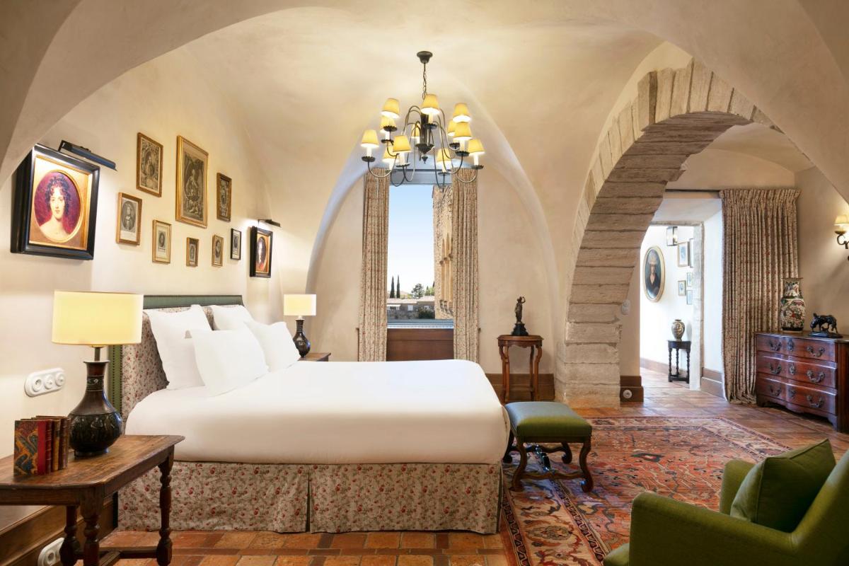 une chambre avec un grand lit blanc dans une pièce dans l'établissement Airelles Gordes, La Bastide, à Gordes