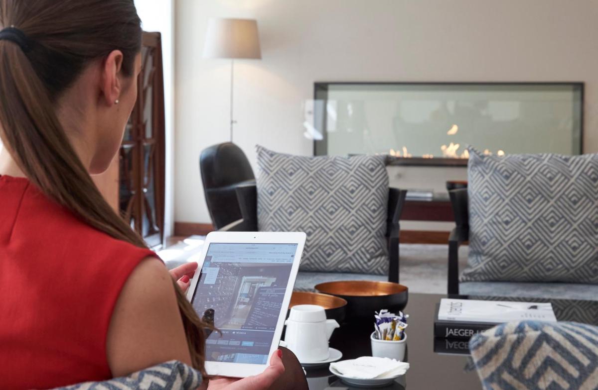 uma mulher a segurar um tablet numa sala de estar em PortoBay Liberdade em Lisboa