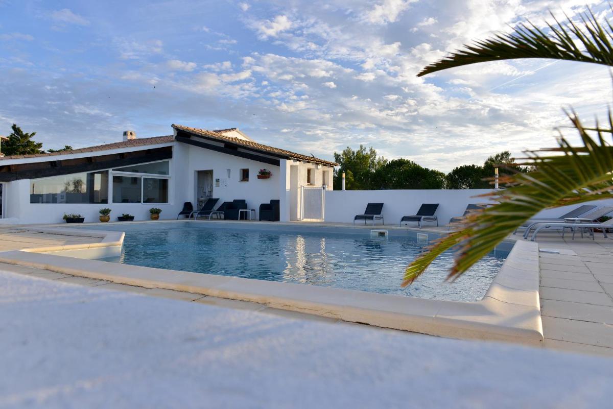 une piscine devant une maison dans l'établissement Mas de la Grenouillère Hôtel et Centre équestre en pleine nature, à Saintes-Maries-de-la-Mer